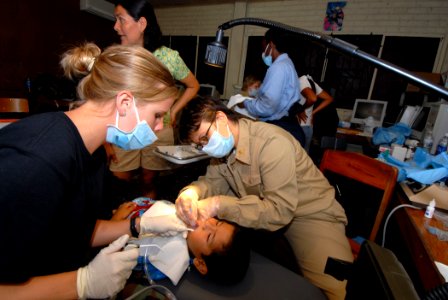 US Navy 070623-N-8704K-007 U.S. Air National Guardsman Staff Sgt. Sarah Boyll (left) and U.S. Public Health Service Lt. j.g. Amy Dayhoff perform dental care for child