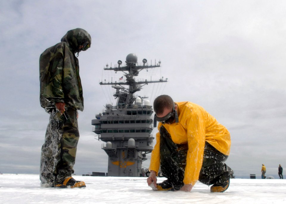 US Navy 070627-N-1229B-106 Members of air department's crash and salvage division fix a clog during an aqueous film forming foam (AFFF) countermeasure wash down aboard Nimitz-Class aircraft carrier USS Abraham Lincoln (CV