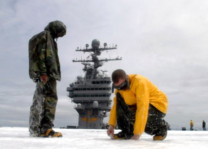 US Navy 070627-N-1229B-106 Members of air department's crash and salvage division fix a clog during an aqueous film forming foam (AFFF) countermeasure wash down aboard Nimitz-Class aircraft carrier USS Abraham Lincoln (CV