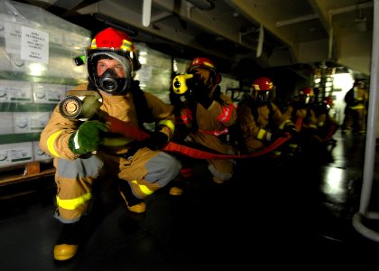 US Navy 070624-N-7981E-100 A hose team assigned to repair locker three sets a reflash watch on a simulated class alpha fire in a storeroom aboard Nimitz-class aircraft carrier USS Abraham Lincoln (CVN 72) during a general quart photo