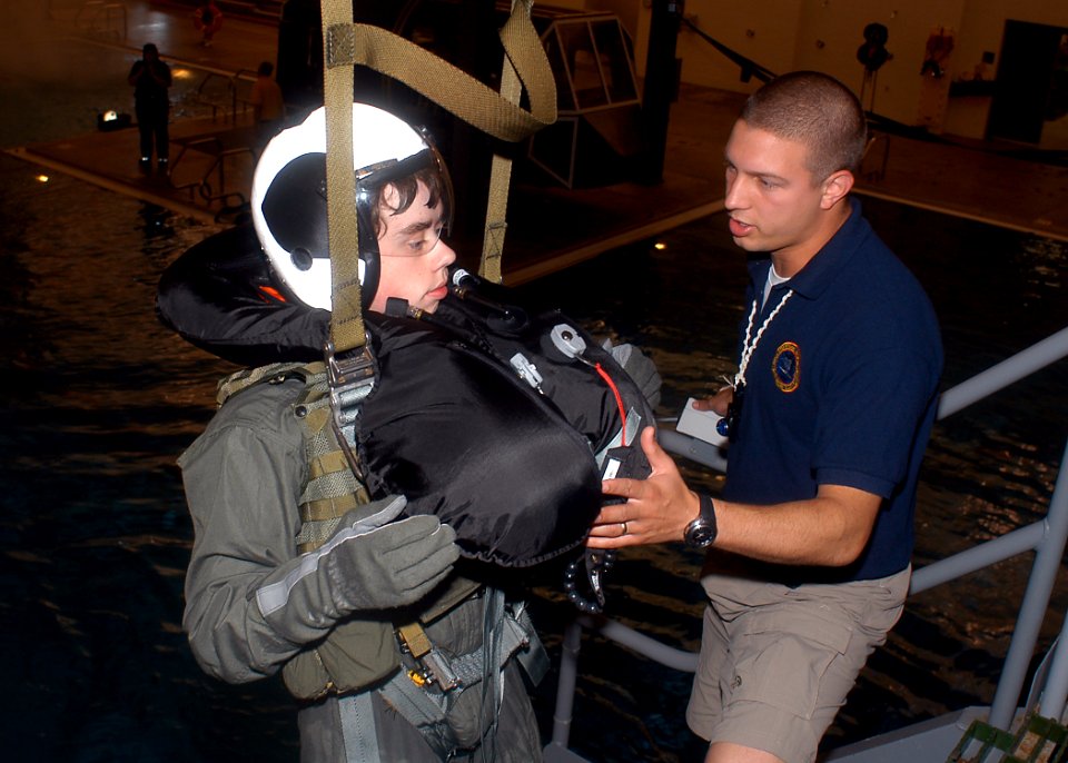 US Navy 070626-N-6247M-001 Hospital Corpsman 2nd Class Brandon McMahan, from Indianapolis, checks the safety harness of a Boy Scout on the parachute over water simulator tower