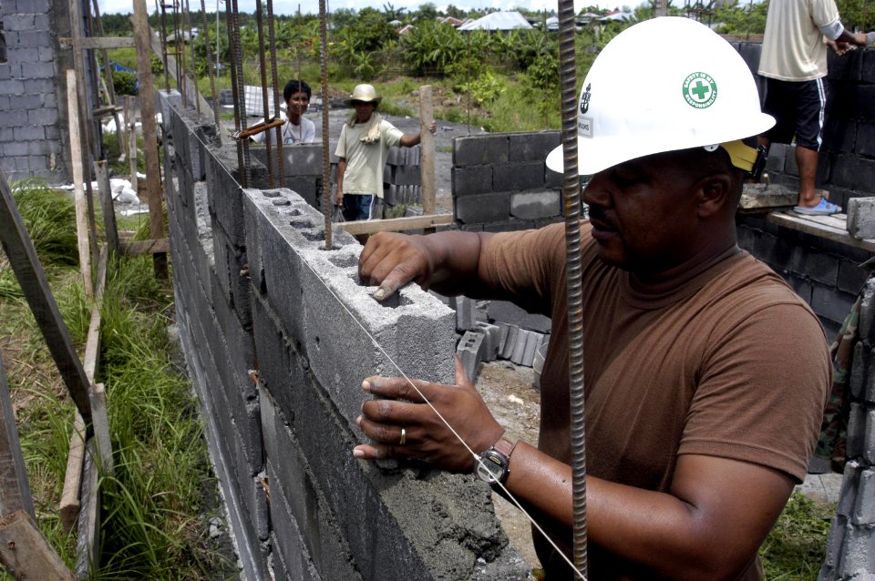 US Navy 070626-N-6410J-053 Senior Chief Builder James Brooks, from Naval Mobile Construction Battalion (NMCB) 7, carefully places a concrete block into place for a house being built in support of Pacific Partnership 2007