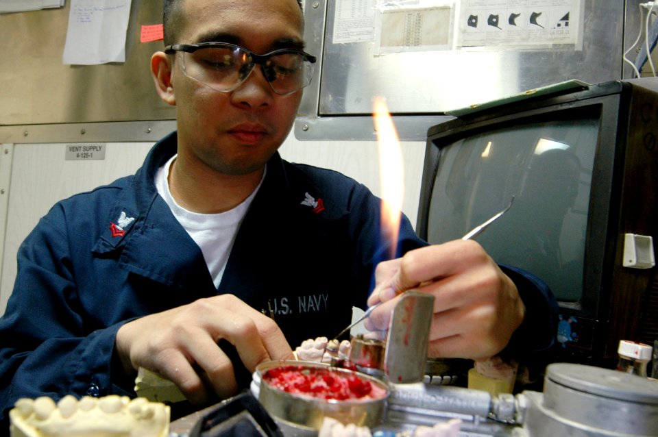 US Navy 070630-N-3136P-031 Hospital Corpsman 2nd Class Erwin Diano, of Bataan, Philippines, crafts a replacement tooth in the dental prosthetics lab for a patient aboard USS Kitty Hawk (CV 63)