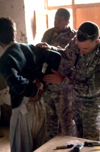 US Navy 070628-A-2394G-047 Lt. Cmdr. Craig Ashby, assigned to the Kalagush provincial reconstruction team, takes a look at a patient in a hospital during a medical capabilities program and humanitarian assistance supply handout photo