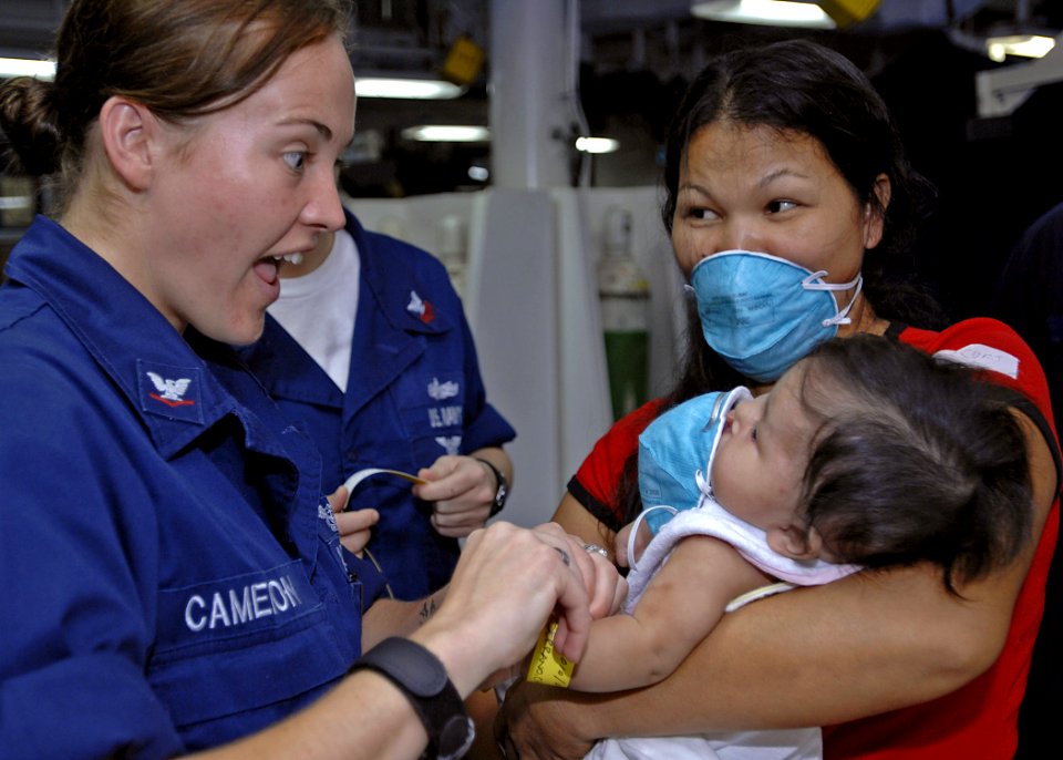 US Navy 070630-N-4954I-031 Aviation Ordnanceman 3rd Class Ashley Cameron plays in the medical ward of amphibious assault ship USS Peleliu (LHA 5) with a Filipino patient who was born with a cleft palate