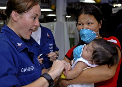 US Navy 070630-N-4954I-031 Aviation Ordnanceman 3rd Class Ashley Cameron plays in the medical ward of amphibious assault ship USS Peleliu (LHA 5) with a Filipino patient who was born with a cleft palate