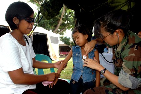 US Navy 070630-N-9421C-027 Cmdr. Con Yee Ling monitors a child's breathing during a Pacific Partnership medical civil action program (MEDCAP) at Travesia Elementary School