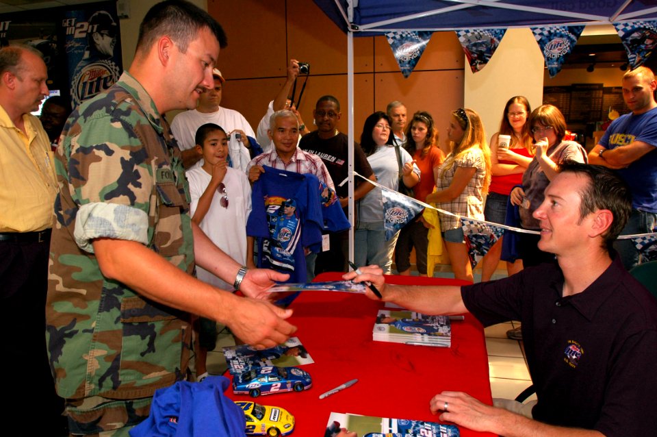 US Navy 070628-N-2456S-021 Senior Chief Engineman William Folkes, training officer assigned to Naval Coastal Warfare Squadron (NCWRON) 4, gets an autographed photo from NASCAR driver Kurt Busch