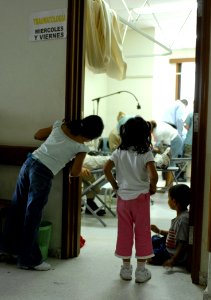 US Navy 070628-N-0194K-230 Children watch as military dentists and technicians, attached to the Military Sealift Command hospital ship USNS Comfort (T-AH 20), provide dental care to patients at the Puerto Barrios National Hospi photo