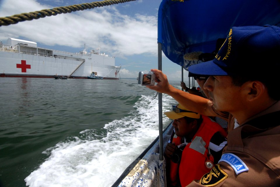 US Navy 070628-N-8704K-010 Guatemalan navy 2nd Lt. Oscar Gomez photographs the anchored Military Sealift Command hospital ship USNS Comfort (T-AH 20) while off the coast of Guatemala