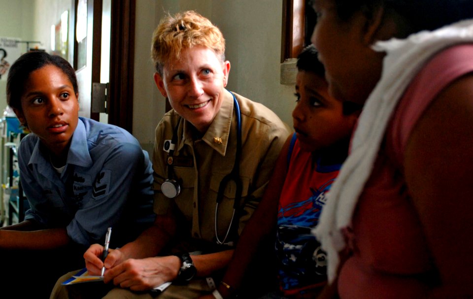 US Navy 070628-N-0194K-075 Ship's Serviceman 2nd Class Ligia Segura translates as Cmdr. Linda Nash, head of nursing aboard the Military Sealift Command hospital ship USNS Comfort (T-AH 20), records patient information