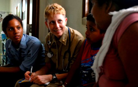 US Navy 070628-N-0194K-075 Ship's Serviceman 2nd Class Ligia Segura translates as Cmdr. Linda Nash, head of nursing aboard the Military Sealift Command hospital ship USNS Comfort (T-AH 20), records patient information