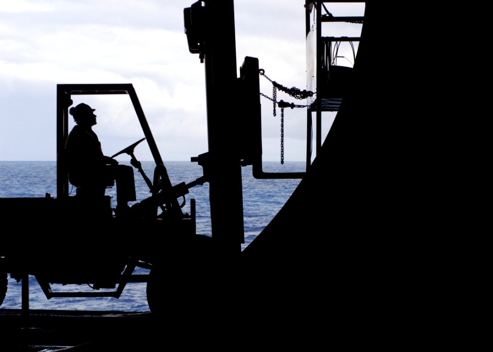 US Navy 070628-N-7981E-165 Aviation Boatswain's Mate (Handling) 3rd Class Matthew Newell uses a forklift to hold up a painting platform beneath an elevator aboard Nimitz-class aircraft carrier USS Abraham Lincoln (CVN 72)
