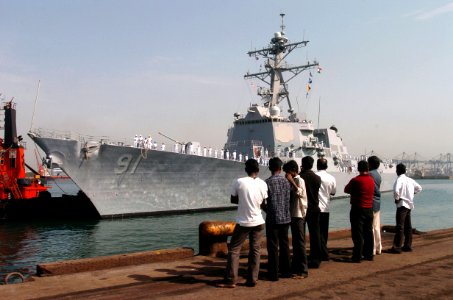 US Navy 070702-N-4420S-098 Residents from India watch as Sailors aboard guided-missile destroyer USS Pinckney (DDG 91) man the rails while entering port