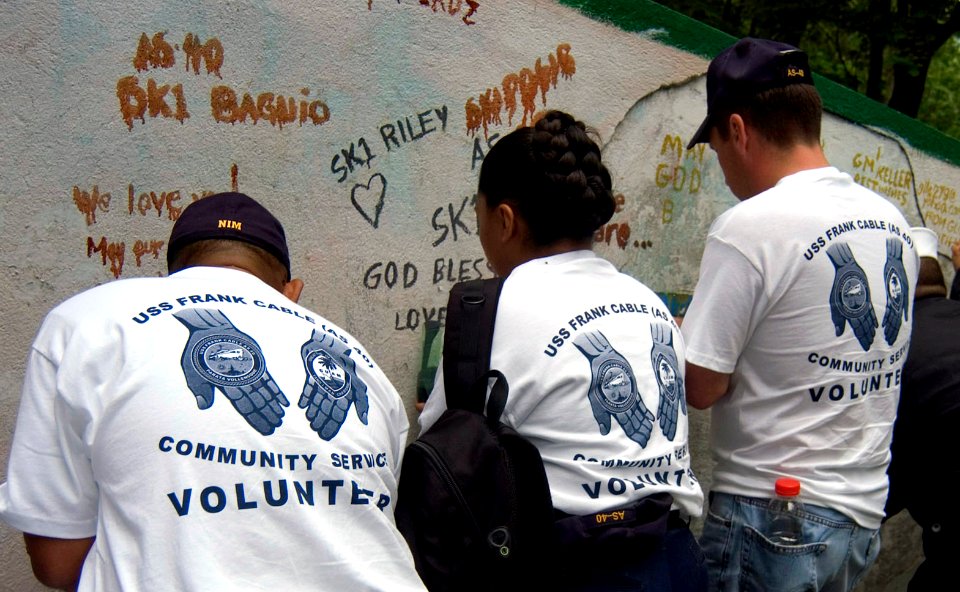 US Navy 070702-N-5253W-005 Sailors from guided-missile destroyer USS Curtis Wilbur (DDG 54) and submarine tender USS Frank Cable (AS 40) paint messages on the Friendship Wall at the Parus Nadezhdy Children's Rehabilitation Cen