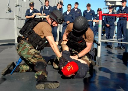 US Navy 070702-N-6710M-028 Members of the visit, board, search and seizure (VBSS) team aboard USS Tortuga (LSD 46) demonstrate the proper weapons tactics for a group of embarked midshipman photo