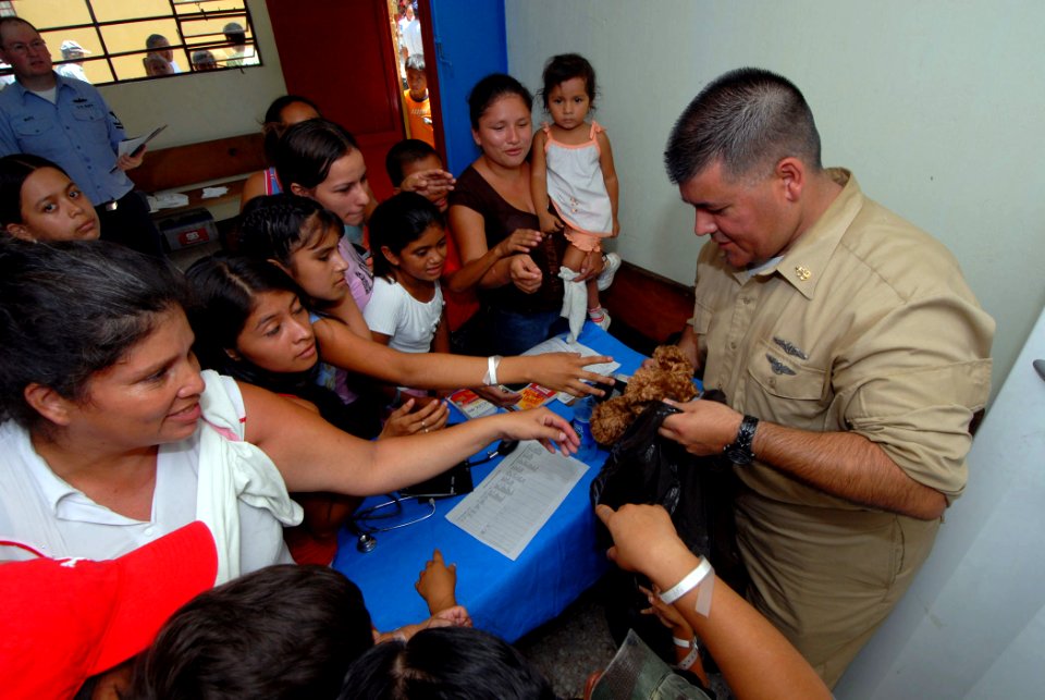 US Navy 070630-N-8704K-049 Senior Chief Hospital Corpsman Anthony Aubright, attached to Military Sealift Command hospital ship USNS Comfort (T-AH 20), hands out stuffed animals to children at Medical Center Morales