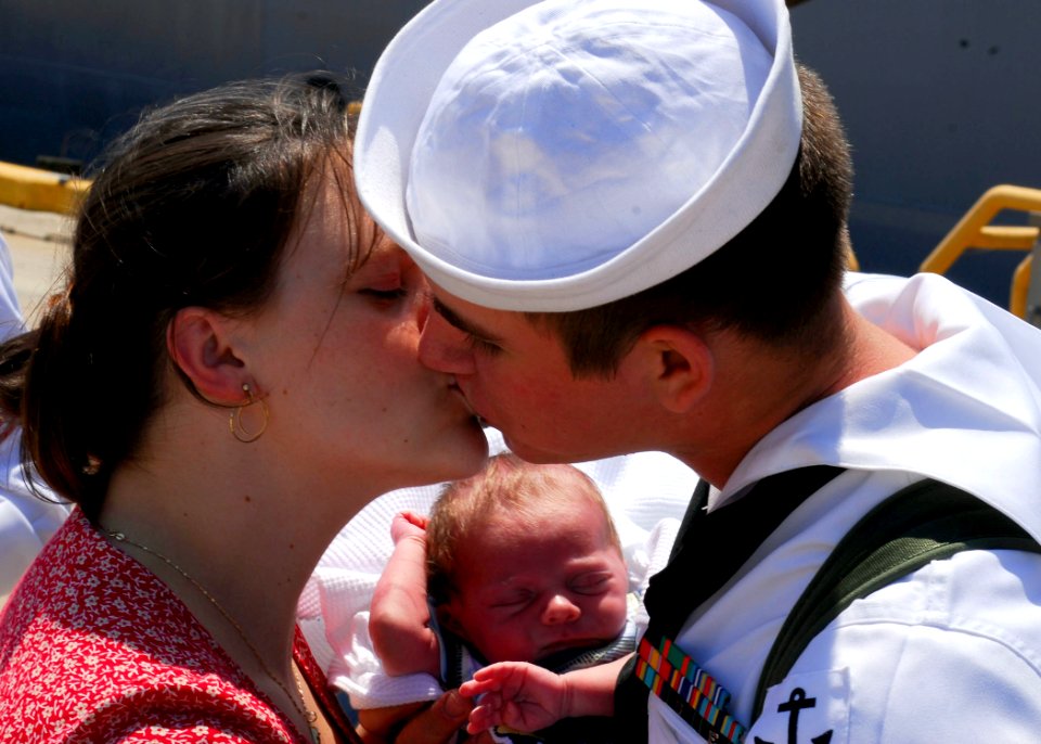 US Navy 070703-N-1688B-072 A new father aboard dock landing ship USS Oak Hill (LSD 51) greets his wife and baby after returning home to Naval Amphibious Base Little Creek