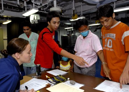 US Navy 070630-N-4954I-020 Aviation Ordnanceman 3rd Class Ashley Cameron and to two Filipino translators assist a Filipino patient during check in for medical care aboard amphibious assault ship USS Peleliu (LHA 5)
