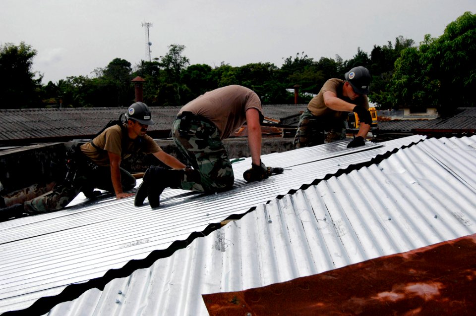 US Navy 070629-N-6278K-006 Sailors assigned to Construction Battalion Maintenance Unit (CBMU) 202, reconstruct a roof at Puerto Barrios Children's Hospital