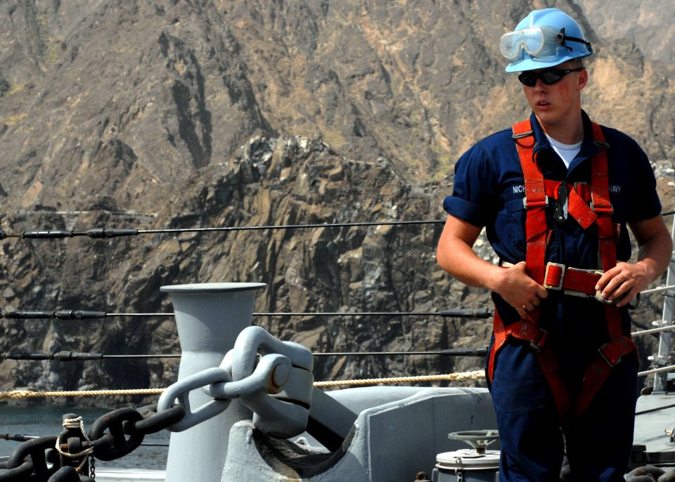 US Navy 070703-N-7498L-095 Seaman Edgar Nicholson positions himself near the anchor chain in preparation for sea-and-anchor detail as guided-missile destroyer USS O'Kane (DDG 77) pulls into port