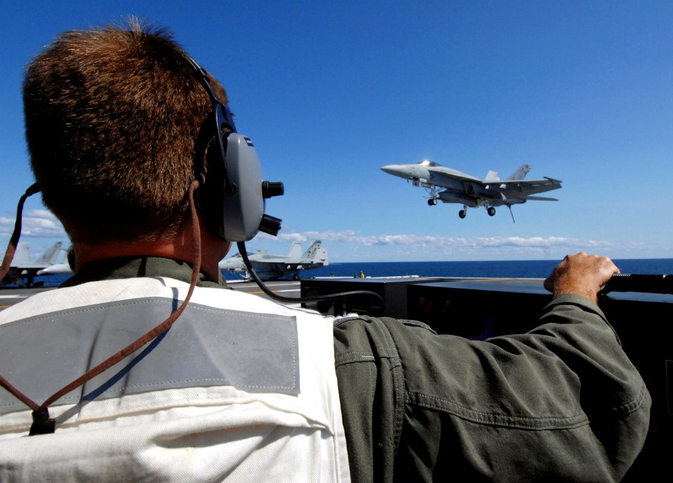 US Navy 070703-N-8923M-121 Landing signal officer (LSO) Lt. Brett Pugsley watches from the LSO platform as an F-A-18E Super Hornet prepares to land aboard Nimitz-class aircraft carrier USS Harry S Truman (CVN 75)