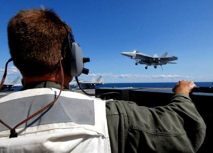 US Navy 070703-N-8923M-121 Landing signal officer (LSO) Lt. Brett Pugsley watches from the LSO platform as an F-A-18E Super Hornet prepares to land aboard Nimitz-class aircraft carrier USS Harry S Truman (CVN 75)