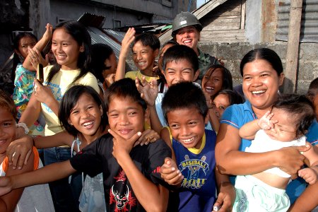 US Navy 070630-N-9421C-245 Equipment Operator 3rd Class Tabitha Smith, attached to Amphibious Construction Battalion (ACB) 1, greets local children during a break from an engineering civil action program at the Tagas River