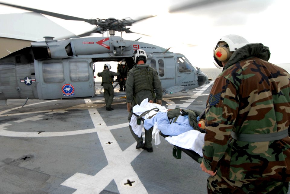 US Navy 070701-N-4238B-004 Aviation Warfare Systems Operator 2nd Class Trevor Ahrendt, attached to Helicopter Sea Combat Squadron (HSC) 28, and Tech. Sgt. Michael Cooper carry a patient