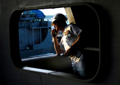 US Navy 070630-N-1229B-042 The ships first lieutenant, John Regelbrugge, oversees the mooring operations as USS Abraham Lincoln (CVN 72) pulls into her homeport at Naval Station Everett photo