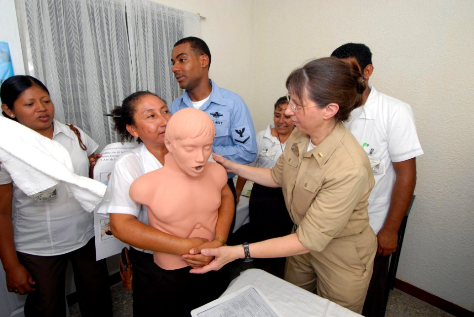 US Navy 070630-N-8704K-022 Cmdr. Patricia Corley, attached to the Military Sealift Command hospital ship USNS Comfort (T-AH 20), demonstrates an abdominal thrust on a training mannequin to Ana Maria Eaton at Medical Center Mora