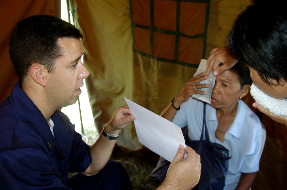 US Navy 070702-N-1752H-110 Cmdr. Matthew Behil performs a routine eye examination on a local patient during a medical civic affairs program (MEDCAP) held at Tabaco Elementary School
