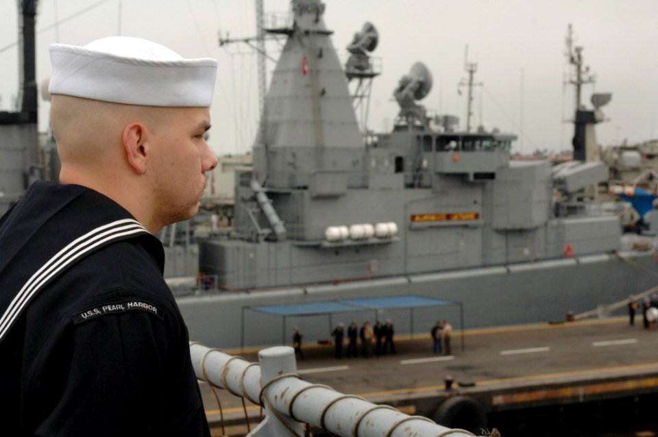 US Navy 070702-N-8861F-031 Sailors aboard dock landing ship USS Pearl Harbor (LSD 52) man the rails with the Chilean frigate Latorre (FFG 14) in the background as the ship pulls into port
