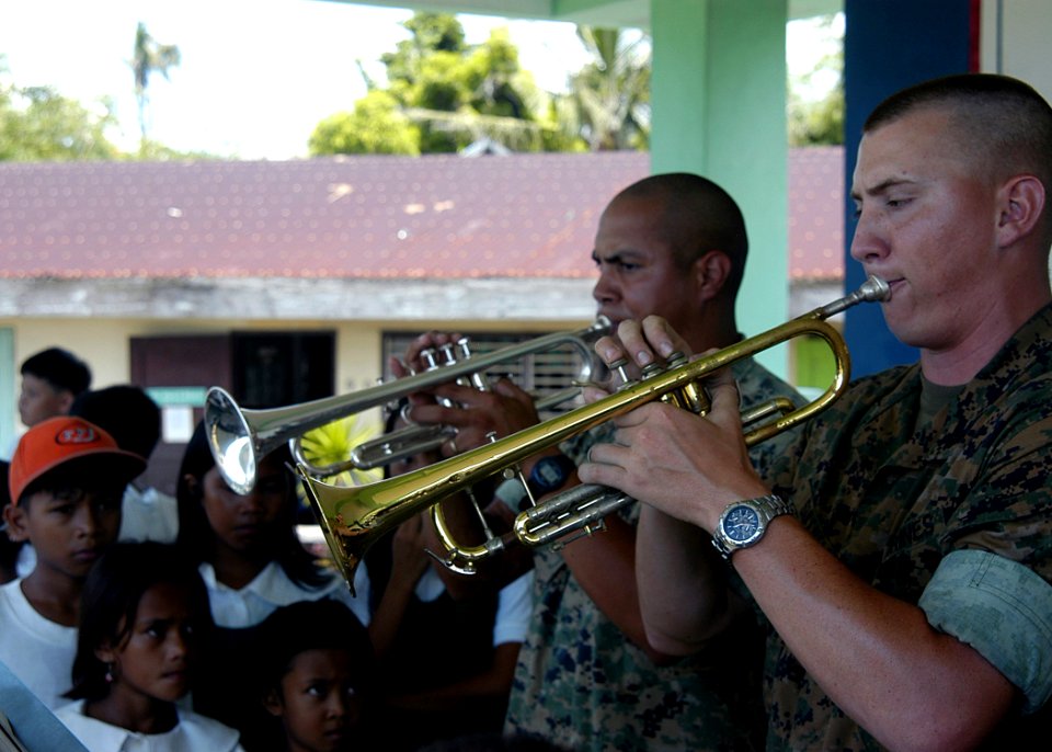US Navy 070703-N-1752H-083 Sgt. Mark Adams and Cpl. Bobby Sullivan, of the Marine Corps Pacific Band, perform for the local children during medical-dental civic affairs programs held at Tabaco Elementary School