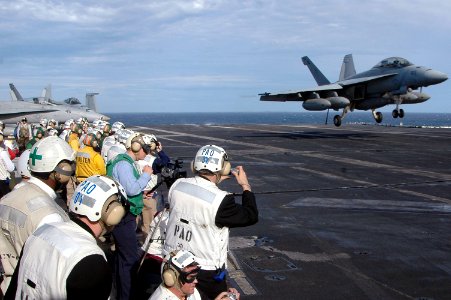 US Navy 070704-N-7883G-141 An F-A-18E Super Hornet, assigned to Strike Fighter Squadron (VFA) 27, lands on USS Kitty Hawk (CV 63) as dozens of Australian visitors watch