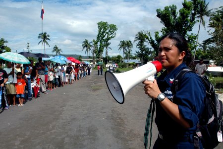 US Navy 070630-N-9421C-054 Operation Specialist 2nd Class Lanny Esteban instructs a crowd waiting a medical screening at Travesia Elementary School