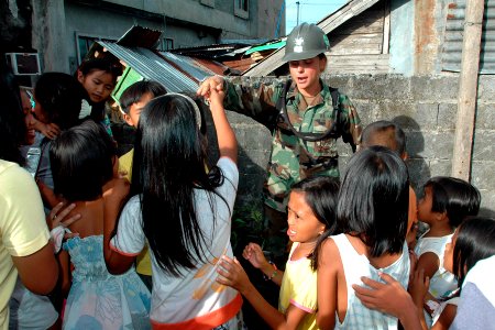 US Navy 070630-N-9421C-214 Equipment Operator 3rd Class Tabatha Smith, attached to Amphibious Construction Battalion (ACB) 1, greets the local youth after Holy Mass ^ Thanksgiving Ceremony offered by the Barangay government