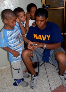 US Navy 070704-N-9486C-001 Master-at-Arms 1st Class Jermaine Bing shares his music with children at the La Casa Rosada home for Dominican children with HIV photo