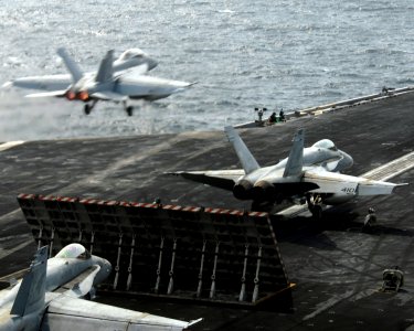 US Navy 070703-N-8157C-057 Two F-A-18C Hornets prepare to launch while an F-A-18F Super Hornet launches from the flight deck of Nimitz-class aircraft carrier USS John C. Stennis (CVN 74) photo