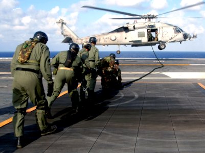 US Navy 070705-N-0455L-028 Sailors assigned to Explosive Ordnance Disposal Unit (EODMU) 6, Det. 22, gather the rope which is used for fast roping exercises to stow back into the SH-60 Seahawk