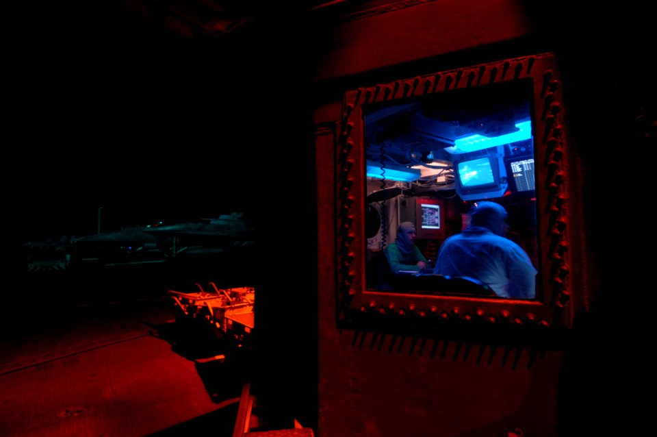 US Navy 070703-N-3729H-258 Aircraft handler Lt. Cmdr. Doug Thornton sits in flight deck control overseeing all flight deck activities during nighttime flight operations on board Nimitz-class aircraft carrier USS John C. Stennis