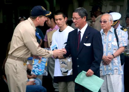 US Navy 070706-N-0483B-001 Cmdr. Ed Cashman, commanding officer of Arleigh Burke-class guided-missile destroyer USS Mustin (DDG 89), welcomes Yokosuka locals as they arrive for the Mustin's Family and Friend Day Cruise