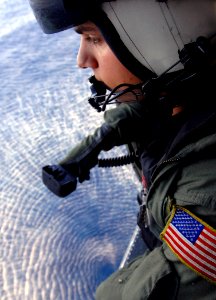 US Navy 070706-N-2984R-273 Aviation Warfare Specialist 2nd Class Justin Dove, assigned to Anti-Submarine Helicopter Squadron (HS) 7, looks out one of the helicopter windows while on a plane guard mission during flight operation