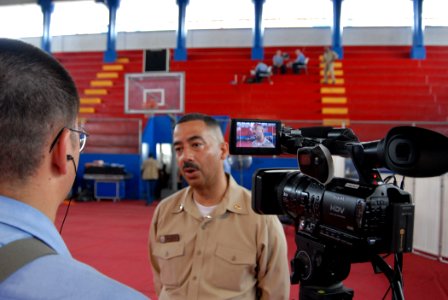 US Navy 070706-N-8704K-201 Mass Communication Specialist 2nd Class Brandon Shelander interviews Lt. Johnny Ramos, site leader for the Paul Brown Arena. Both Shelander and Ramos are attached to Military Sealift Command hospital photo