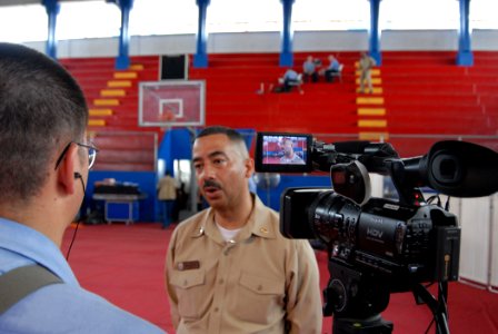 US Navy 070706-N-8704K-201 Mass Communication Specialist 2nd Class Brandon Shelander interviews Lt. Johnny Ramos, site leader for the Paul Brown Arena. Both Shelander and Ramos are attached to Military Sealift Command hospital