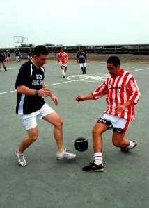 US Navy 070704-N-4021H-012 Information Systems Technician 3rd Class Johnathan Fehling, assigned to dock landing ship USS Pearl Harbor (LSD 52), makes a push to the goal while playing in a soccer tournament against a partner nat