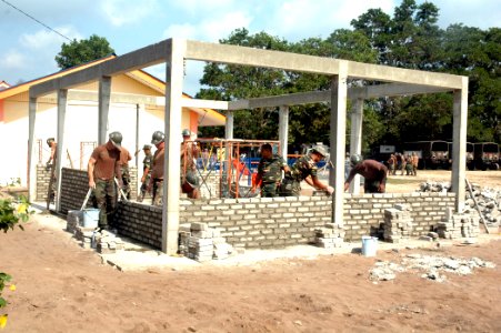 US Navy 070703-N-7783B-007 Members of Naval Mobile Construction Battalion (NMCB) 7 and the Royal Malaysian Army Engineers work together to build a new schoolhouse at the Sekolah Kebangsaan Meraga Beris Elementary School
