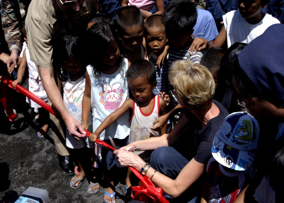 US Navy 070704-N-6410J-024 U.S. Ambassador to the Philippines, the Honorable Kristie A. Kenney prepares to cut a ribbon with small children during a ribbon cutting ceremony at the Honest Ansilag Duraga Transition Center