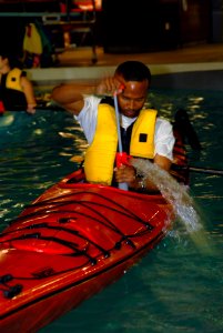 US Navy 070706-N-7656R-003 Lt. David Holmes, assigned to Electronic Attack Squadron (VAQ) 140, pumps water out of his kayak during a kayaking class offered by Morale, Welfare and Recreation