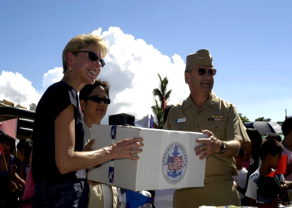 US Navy 070704-N-6410J-116 U.S. Ambassador to the Philippines, the Honorable Kristie A. Kenney and Vice Adm. Doug Crowder hand a box to a Philippine official during the Project Handclasp ceremony